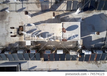 Solar panel and television antennas at the roof of building. 74574123