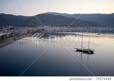 Aerial view of boats, mountains and city at sunset. Aerial view of boats, mountains and city at sunset. 74574409