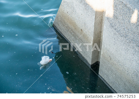 A photo of a plastic bag floating in the sea. Image of environmental problems. A photo of a plastic bag floating in the sea. Image of environmental problems. 74575253