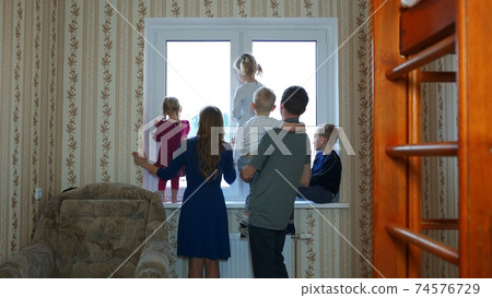 A large and friendly family at the window during quarantine and waved. A large and friendly family at the window during quarantine and waved. 74576729
