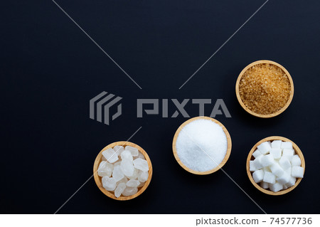 Various types of sugar on dark background. 74577736