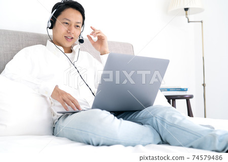 Young man having a video chat at home Young man having a video chat at home 74579486