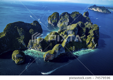 Top view of isolated rocky tropical island with turquoise water and white beach. Top view of isolated rocky tropical island with turquoise water and white beach. 74579596