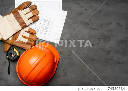 Hardhat, gloves and blueprints of a builder 74580384