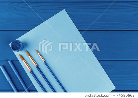 Blue paint brushes on classic blue background, view from above 74580662