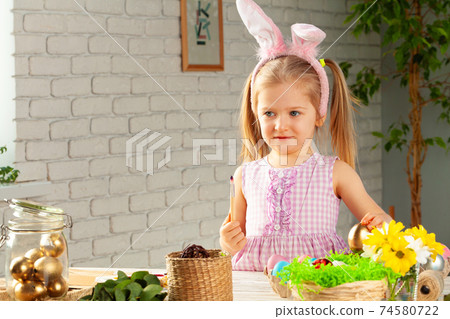 Portrait of a cute girl with paintbrush ready to paint eggs Portrait of a cute girl with paintbrush ready to paint eggs 74580722