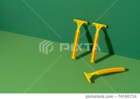 Disposable razor on green background, studio shot 74580724
