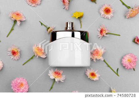 Bottle of fragrance surrounded by flower buds Bottle of fragrance surrounded by flower buds 74580728