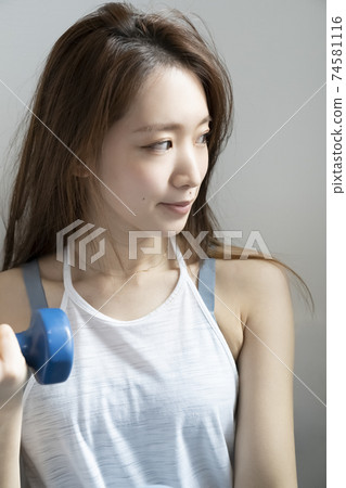 運動服的婦女做肌肉訓練 運動服的婦女做肌肉訓練 74581116