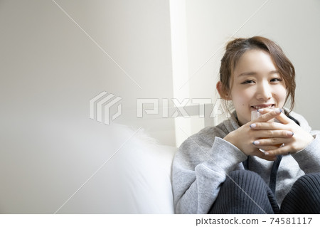 A woman who drinks tea in a room A woman who drinks tea in a room 74581117