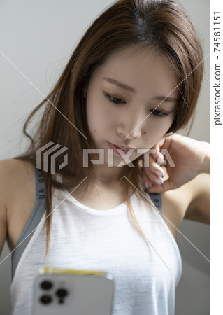 A woman looking at a smartphone in sportswear A woman looking at a smartphone in sportswear 74581151