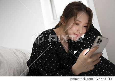 看智能手機的婦女在屋子裡 74581215