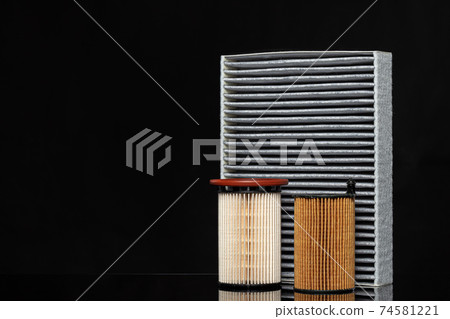 Car engine filter on dark background, close up. Car engine filter on dark background, close up. 74581221