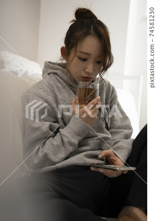 A woman who drinks tea in a room A woman who drinks tea in a room 74581230