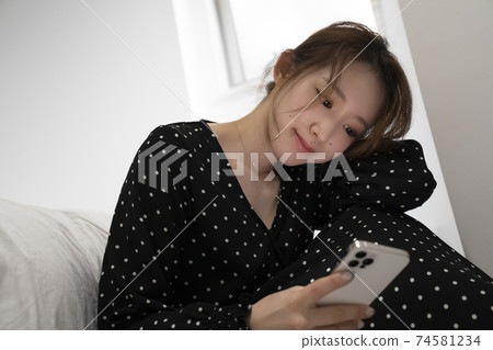 Woman looking at smartphone in the room 74581234
