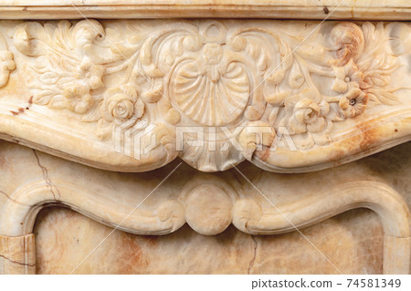 Carved patterns on stone luxury fireplace close up Carved patterns on stone luxury fireplace close up 74581349