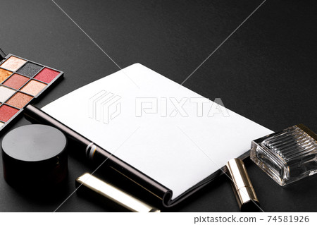 various makeup products on black texture background. 74581926