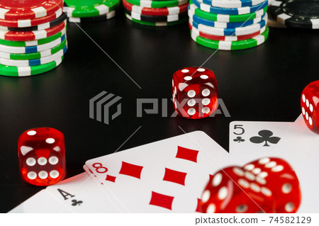 Dice and chips on black table close up Dice and chips on black table close up 74582129