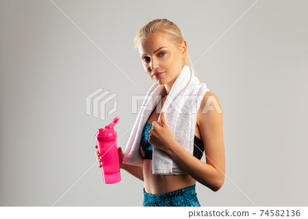 Beautiful young sports woman posing with towel on neck 74582136