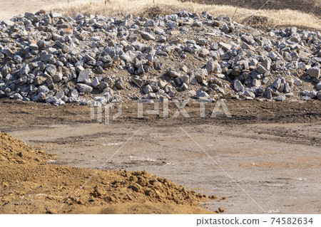 Land under construction where soil and concrete lumps are placed Land under construction where soil and concrete lumps are placed 74582634