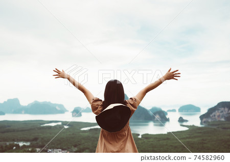 Freedom concept. Happy young woman enjoying freedom time and open hands on nature river and mountain Freedom concept. Happy young woman enjoying freedom time and open hands on nature river and mountain 74582960