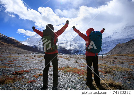 Two women hikers hiking  in winter mountains 74583252