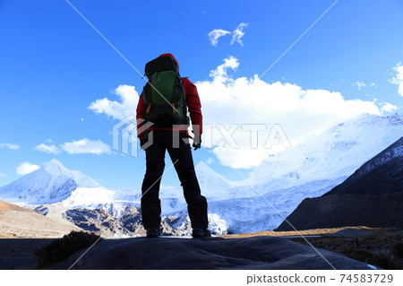 Woman backpacker hiking in winter mountains Woman backpacker hiking in winter mountains 74583729