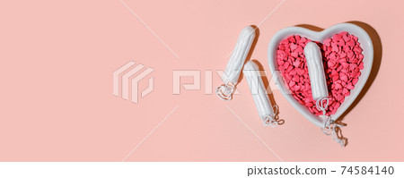 Medical female tampons and heart shape plate on pink background. Hygienic white organic tampon for women. Menstruation, means of protection. Stylish minimal concept, banner, flyer, hard shadow 74584140