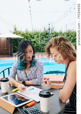 Business women discussing report 74584698
