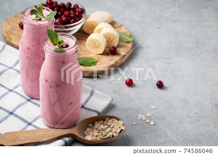 Homemade yogurt smoothie with banana, cranberry and oatmeal, copy space Homemade yogurt smoothie with banana, cranberry and oatmeal, copy space 74586046