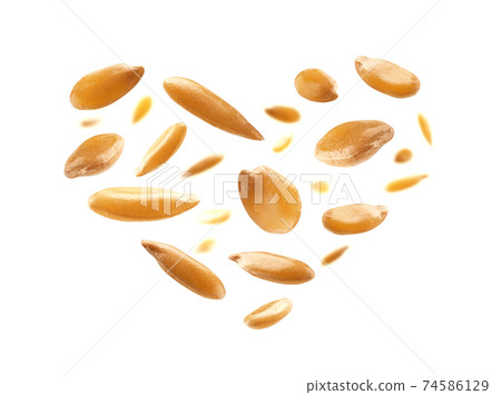 Flax seeds are in the shape of a heart on a white background 74586129