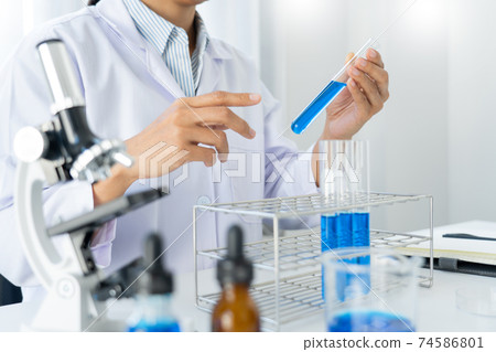 scientists researching in laboratory in white lab coat, gloves analysing, looking at test tubes sample, biotechnology concept scientists researching in laboratory in white lab coat, gloves analysing, looking at test tubes sample, biotechnology concept 74586801