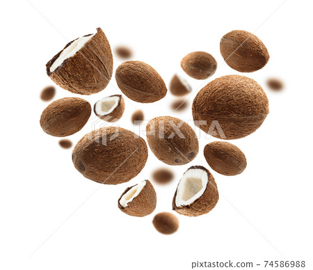 Whole and half cocoanuts in the shape of a heart on a white background Whole and half cocoanuts in the shape of a heart on a white background 74586988