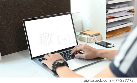 Cropped shot of young man working online with computer laptop at home. 74587772