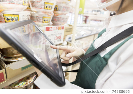 A female employee with a mouse shield who manages inventory at a supermarket 74588695