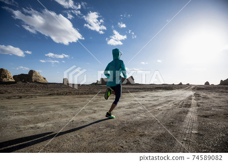 Fitness woman trail runner cross country running  on sand desert 74589082