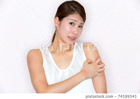 一名婦女過敏和撓她的手臂。 一名婦女過敏和撓她的手臂。 74589343