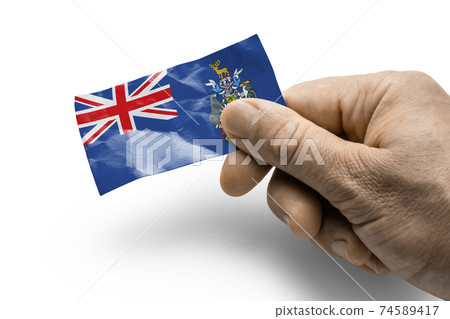 Hand holding a card with a national flag the South Georgia and the South Sandwich Islands 74589417
