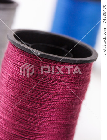 Spools of colorful thread as accessories for using in sewing. 74589470
