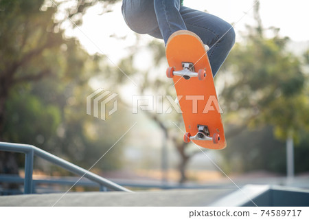 Asian woman skateboarder skateboarding at skatepark Asian woman skateboarder skateboarding at skatepark 74589717