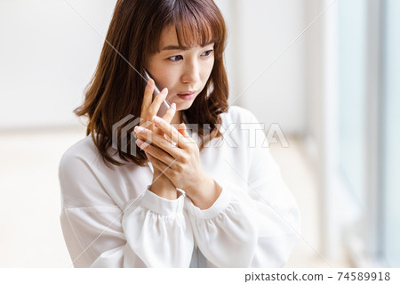 A woman who puts her smartphone on her ear and shows an annoying expression 74589918