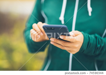 Asian woman using smartphone outdoors 74590344