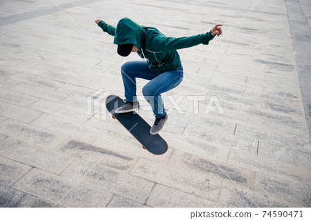 Asian woman skateboarder skateboarding in modern city Asian woman skateboarder skateboarding in modern city 74590471