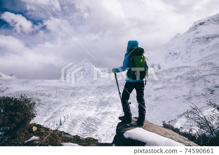 Successful woman backpacker hiking in winter mountains Successful woman backpacker hiking in winter mountains 74590661