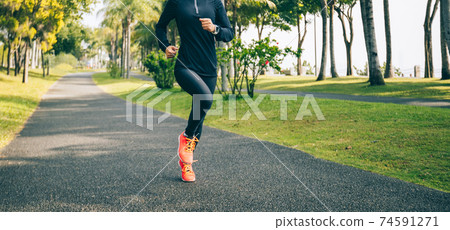 Fitness woman running training for marathon on sunny tropical park trail Fitness woman running training for marathon on sunny tropical park trail 74591271