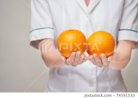 nutritionist doctor healthy lifestyle concept - holding orange fruit nutritionist doctor healthy lifestyle concept - holding orange fruit 74591510