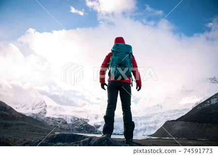 Solo woman backpacker hiking in winter mountains 74591773