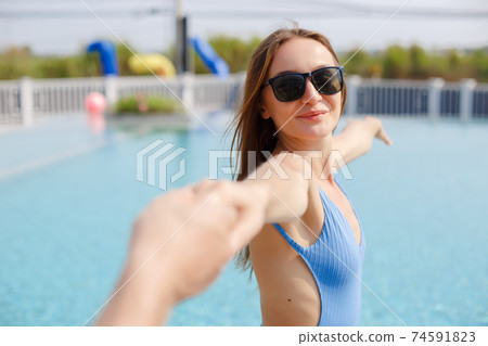Happy sexy beautiful woman wear sunglass relax time at poolside. Happy sexy beautiful woman wear sunglass relax time at poolside. 74591823