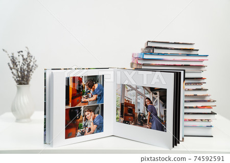 open photobook from photo shoots of woman with a microscope. stack of books open photobook from photo shoots of woman with a microscope. stack of books 74592591