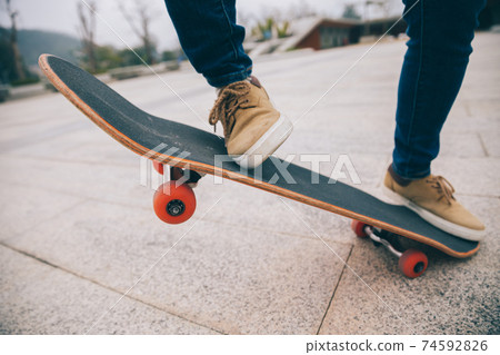 Skateboarder skateboarding outdoors on sunny morning 74592826